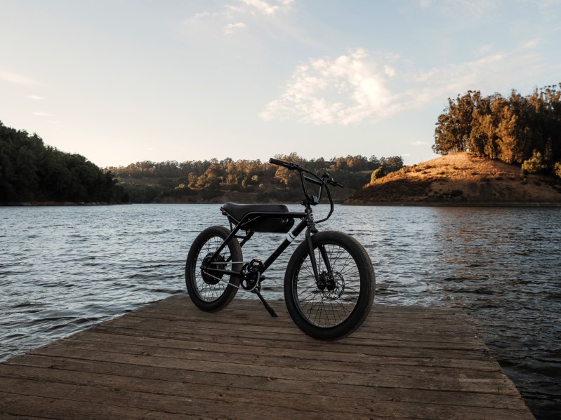 单E24电机停靠湖面 后台山坡上有落日