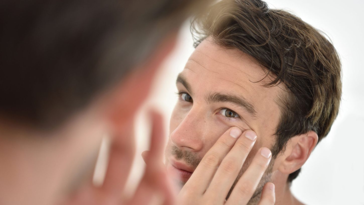 Stock-Man-Looking-in-Mirror-at-Skin