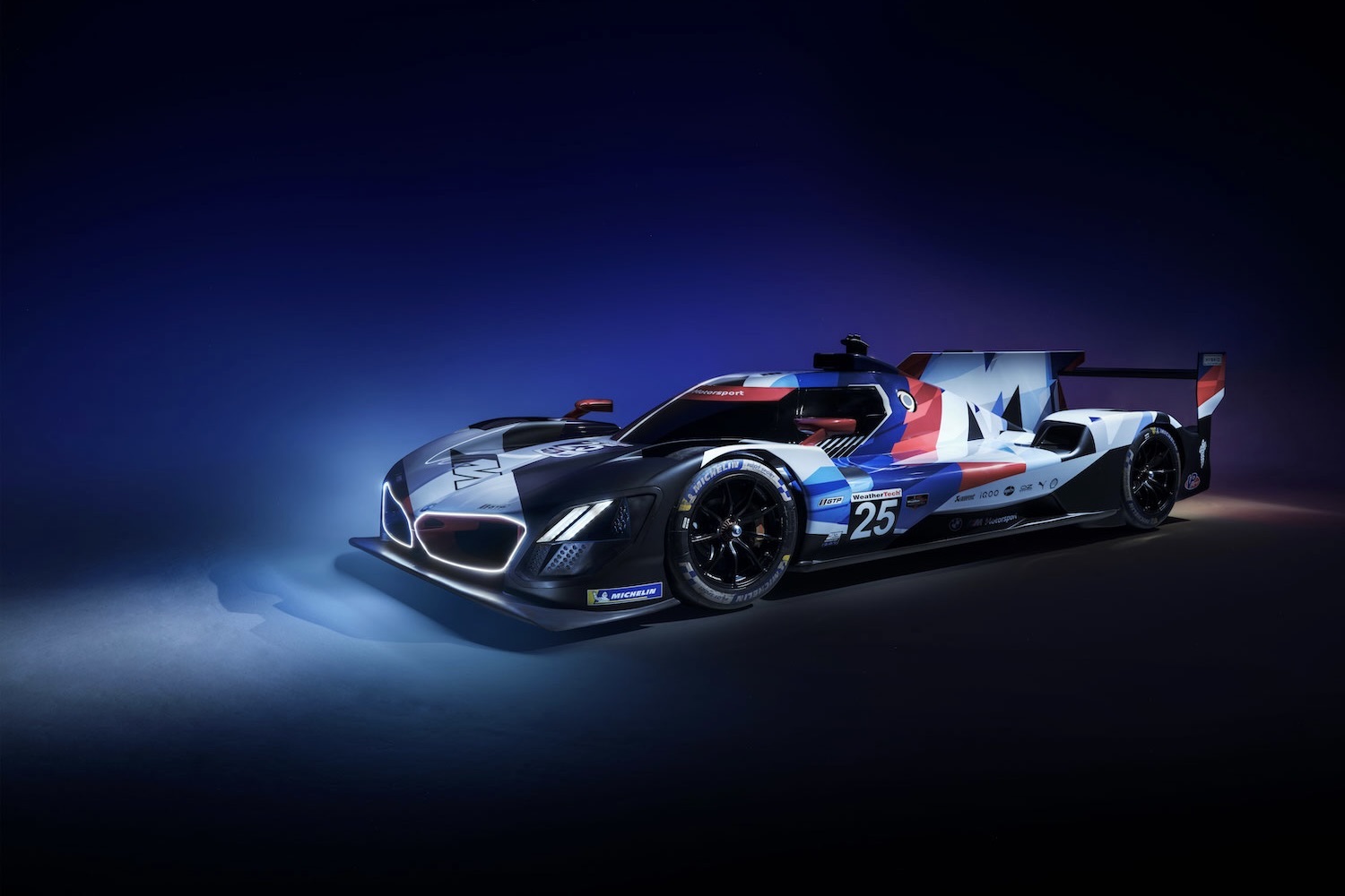 BMWM8混合V8前端角停在蓝工作室墙上并开灯