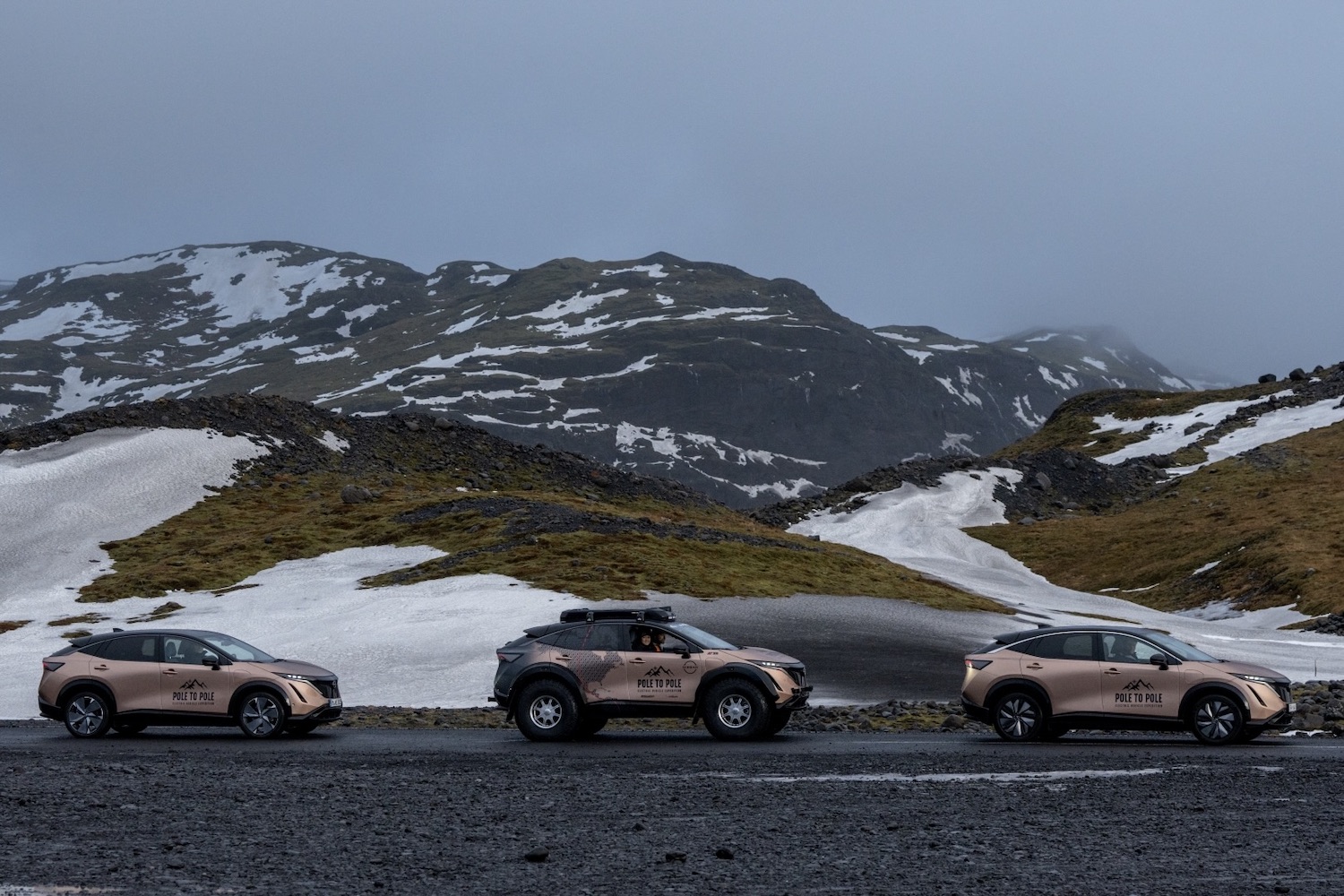 三位Nissan Ariyas停靠路边雪覆盖山前