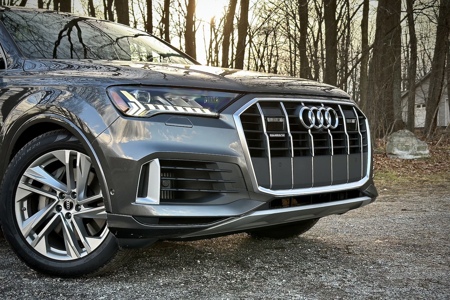 近距离拍2022AudiQ7Prestige前端停在树前的石堆上