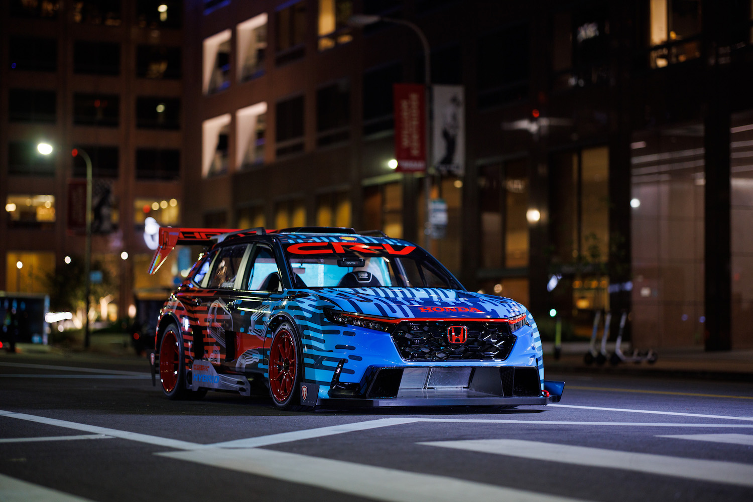 Honda CR-V混合赛车手前端近距离夜间停在路中间大楼前