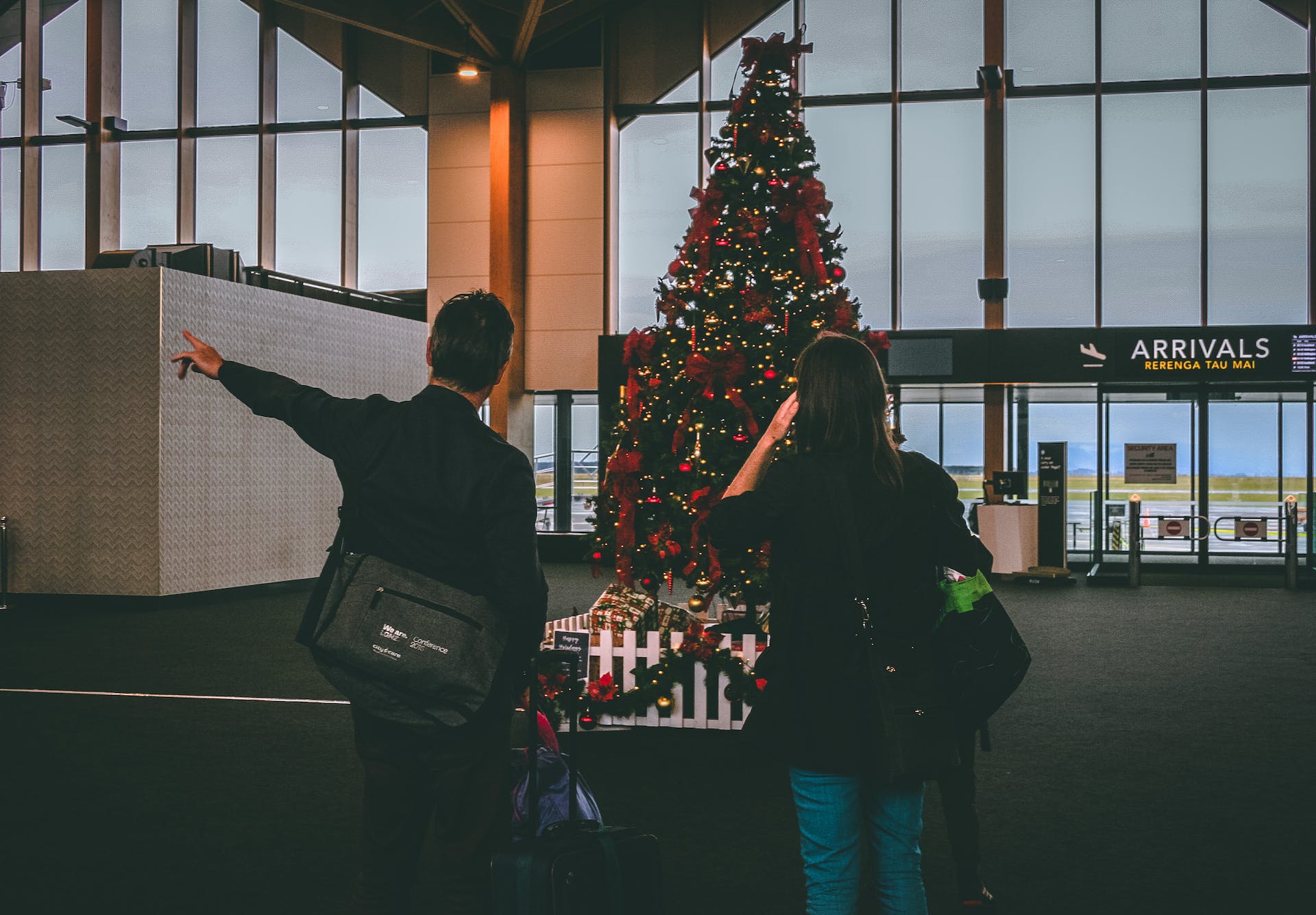 机场内一男一女站在 Christmas树前